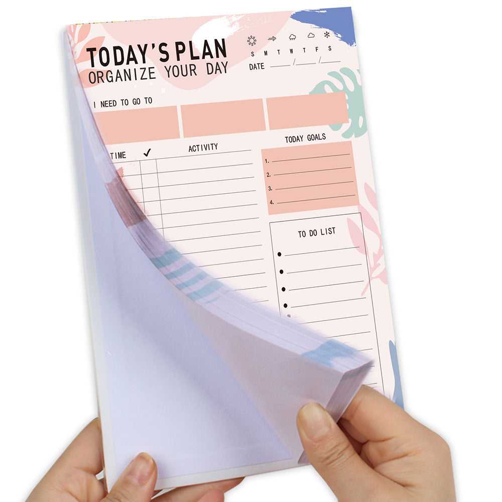 Notebook with a planner layout held by hands on a white background